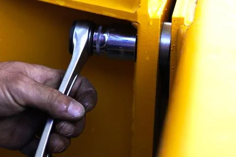 A close-up of a worker using a wrench. 스톡 사진