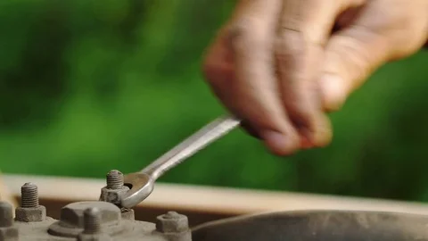 Close-up, the worker's arm unscrews the bolt Stock Footage 77858612