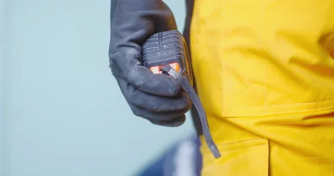 Close-up of a worker's gloved hand holding a tape measure Stockbeeldmateriaal 150724052
