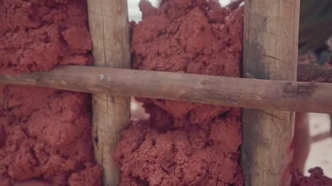 Close up of a worker's hand pressing raw earth into a wooden lattice. Stock Footage 341052172
