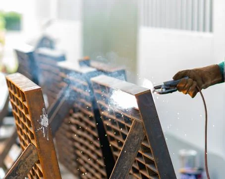 Close-up of a worker's hand in a protective leather glove welding a heavy i.. Stock Photos