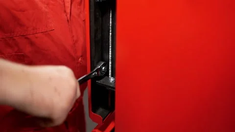 Close-up of a worker's hand in a red robe who tightens the nut with a wrench Stock-Footage 167922865