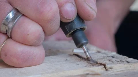 Close-up of worker's hand with tools hacking wood Stock Photos