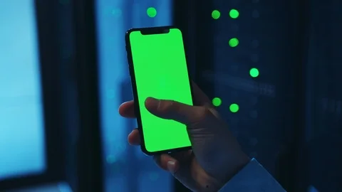 Close-up worker's hand using greenscreen mock-up vertical smartphone inside Stock Footage 121159738