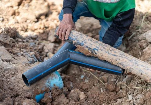 Close-up of a worker's hands aligning HDPE plastic piping and fittings insi.. Stock Photos