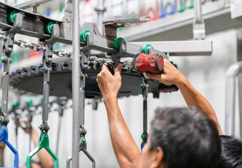 Close-up of a worker's hands assembling metal chain components and trolley .. Stock-Fotos