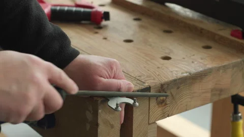 Close-up of a workers hands using a metal file to sharpen or smooth a detail on Stock Footage 318752279