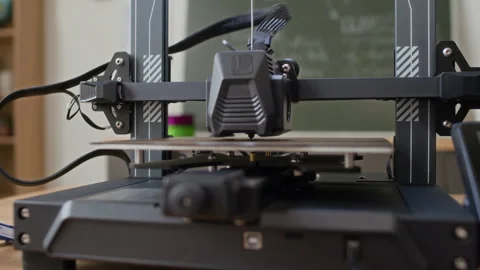 Close up of Working Extruder of 3D Printer in Classroom Stockbeeldmateriaal 335688274
