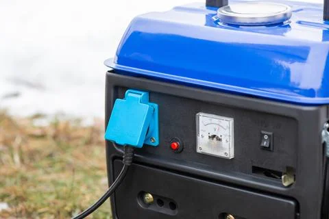 Close up of working gasoline generator with plugged in socket Stock Photos