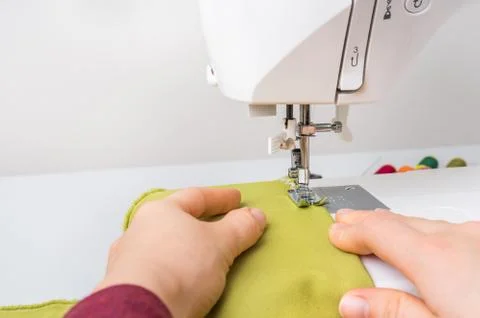 	Close-up of working sewing machine foot with green cloth Stock Photos