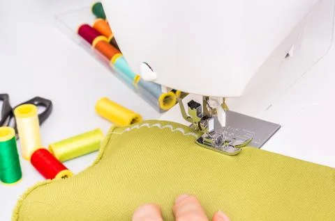 	Close-up of working sewing machine foot with green cloth Stock Photos