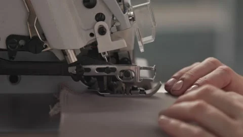 Close up working on sewing machine stitching side of fabric on a sewing machine Stock Footage 231015258
