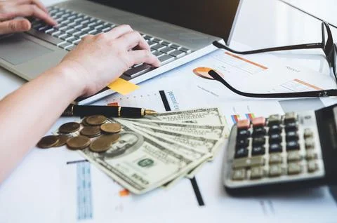 Close up of working woman hand using laptop computer on office desk with mo.. Stock Photos