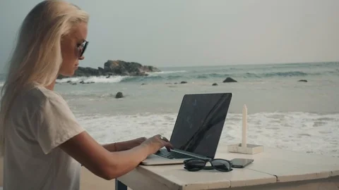 A close up of the workplace on the beach. Young lady is looking for a job in the Stock Footage 85610976