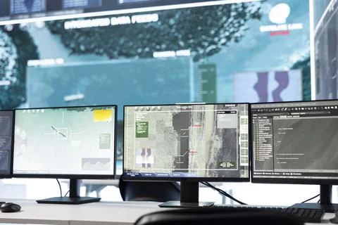 Close up of workstations in empty military command center with satellite maps Stock Photos