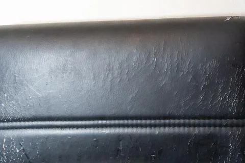 Close-up of worn black vinyl surface showing texture and scratches, perfect for Stock Photos