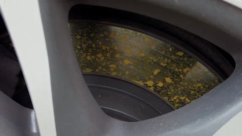 Close-up of worn car brake disc behind alloy wheel spokes with rust and surface 스톡 동영상 346558182
