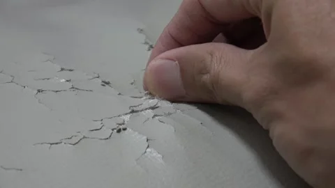 A close-up of worn, cracked leather on an old sofa. Hand picking worn surface. Stock Footage 329830770