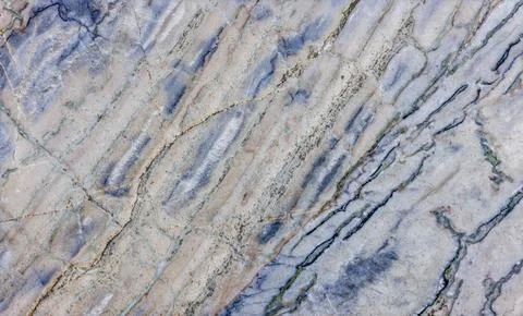 Close-Up of Worn Marble with Diagonal Blue and Tan Veins 库存照片