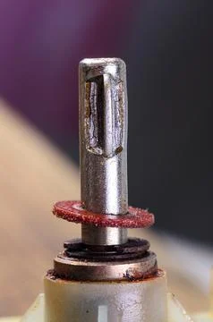 Close-up of a worn metal component with a red abrasive disc and other parts Stock Photos