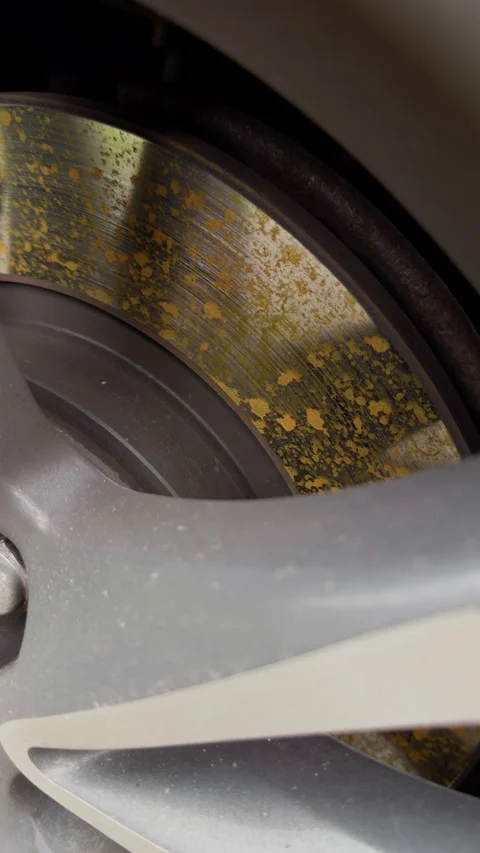 Close up of worn motorcycle brake disc and wheel rim with rusted metal surface Stock Footage 346558193