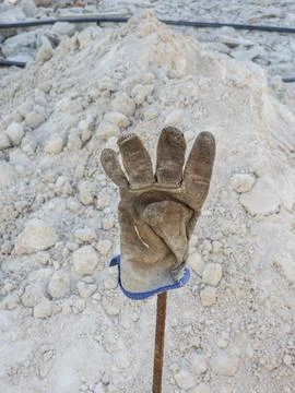 Close up of a worn out leather work glove on a vertical rebar post near a p.. Stock Photos
