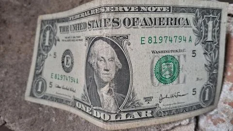 Close-up of a worn US one dollar bill. Focus on detailed currency design and Stock Photos
