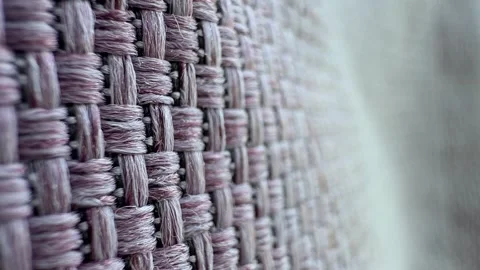 Close-up of a woven fabric texture with a soft, muted color palette. The Video stock 324625365