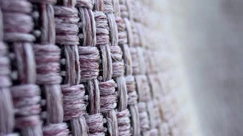 Close-up of a woven fabric texture with a soft purple hue. The intricate Stock Footage 325659860