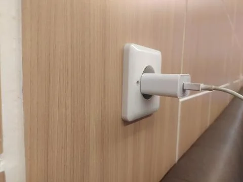 Close up of the wrapped cable on the mobile phone charger plugged in Stock Photos