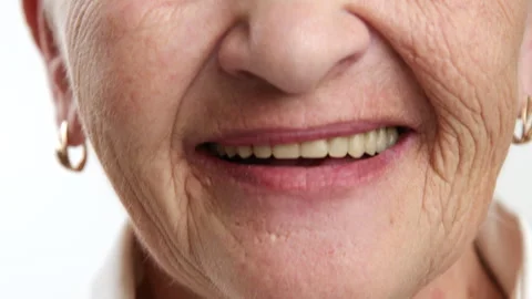 Close up of wrinkled female face with arrows on eyes, 60-70 years, smiling Stock Footage 261908665