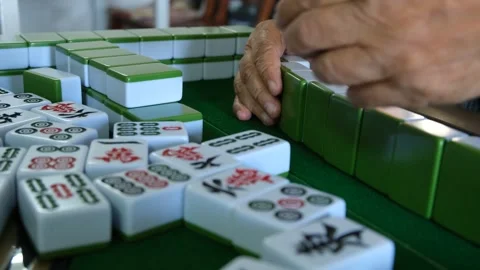 Close up of wrinkled hands of an elderly Asian person playing mahjong on table Stock Footage 290477388