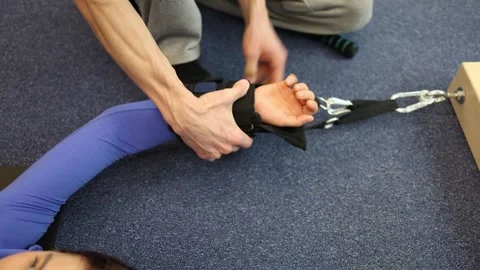 Close-up of a wrist being secured with a padded strap and resistance cord before Stock Footage 306596815