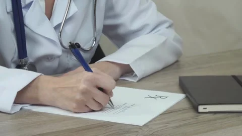 Close-up writing Young physician with stethoscope prescribes treatment to Video stock 336587582
