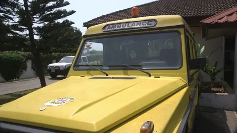 Close Up Yellow ambulance parked outside a Ghanaian hospital building Stock Footage 341852503