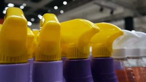 Close-up of yellow and white plastic sprayers on plastic bottles with household Stock-Footage 308400729