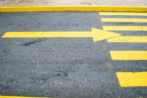 Close up to a yellow arrow in the direction to the right, yellow pedestrian c Stock Photos
