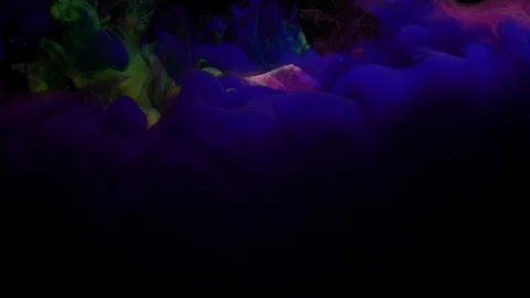 Close-up of yellow blue and violet and green clouds of paint fall under water Stock Footage 114322305