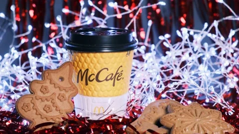 Close-up of yellow branded McCafe cup with gingerbread of different shapes Vídeo Stock 145605520