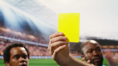 Close-up of yellow card held by referee hand after rules violation during match Video stock 337995245