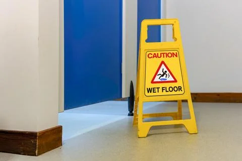 Close-up of yellow Caution Wet Floor warning sign Fotos de archivo