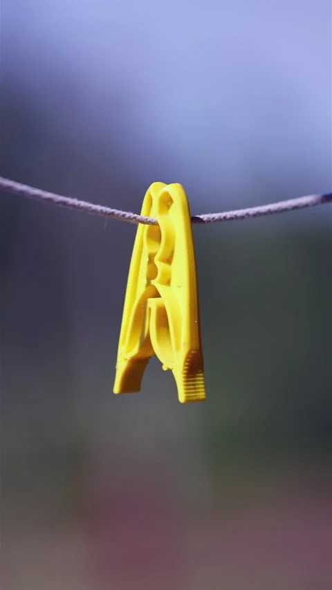 Close-Up Of Yellow Clothespin Hanging On Laundry Line Outdoors. Vertical. Video stock 295294841