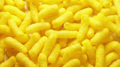 Close up of yellow corn sticks on a rotating table. Corn based processed food Stock Footage 338212393