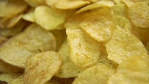 Close up of yellow crispy potato chips rotating slowly Stock Footage 333835373