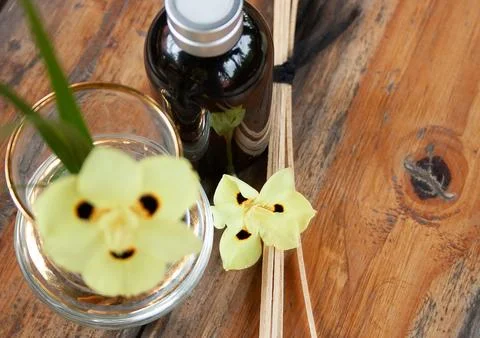 Close-up of yellow flower with fraganced diffuser bottle. Spa concept. Stock Photos