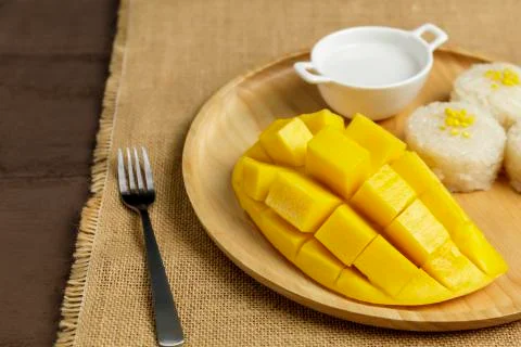 Close up Yellow half  mango with small fork. Mango fruit cubes on the wooden  Stock Photos