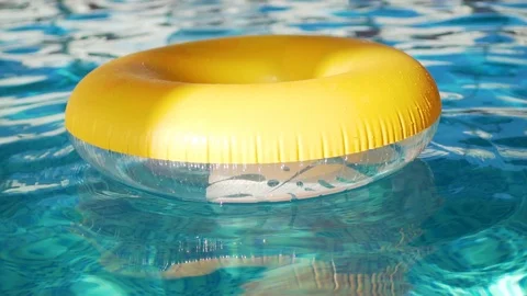 Close up of yellow inflatable swimming circle swinging on turquoise water in swi Stock Footage 121458342