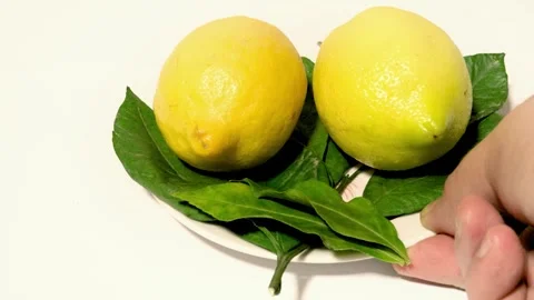 Close-up of Yellow Lemons on a Plate Placed on a White Table Видео 331611518