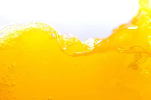 Close-up of yellow liquid splash with bubbles and foam Stock Photos