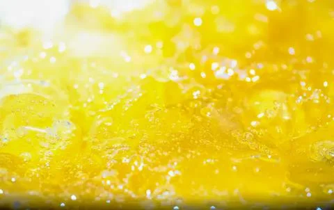 Close-up of yellow liquid splash with bubbles and reflections Stock Photos
